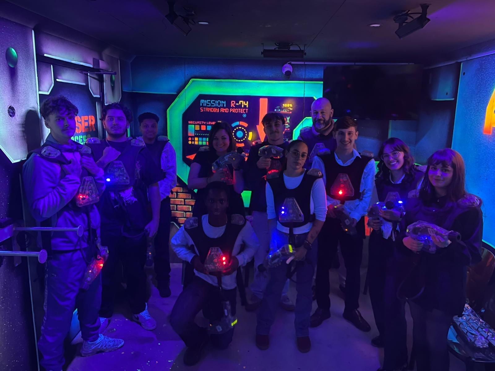Groupe jouant au laser game dans une salle colorée.